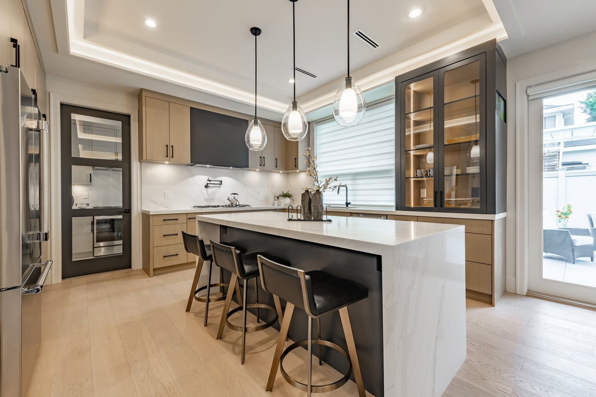 Cocina moderna con encimera blanca y taburetes